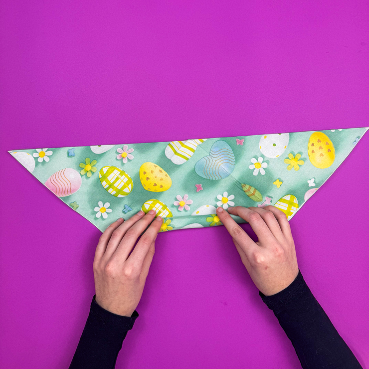 Ein Bild das zeigt, wie die Serviette zu einem langen Band eingerollt wird.