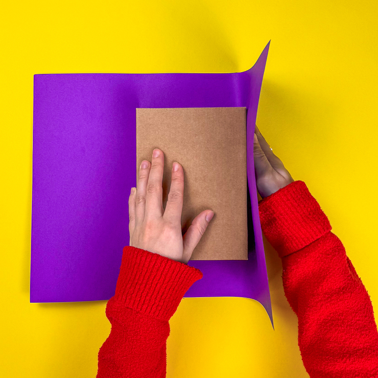 Ein Bild das zeigt, wie das Geschenk mittig auf dem Papier platziert wird.