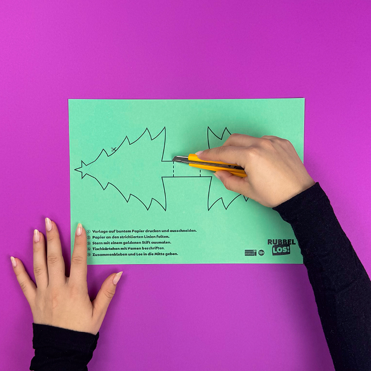 Ein Bild das zeigt, wie der Weihnachtsbaum mit Cutter ausgeschnitten wird.