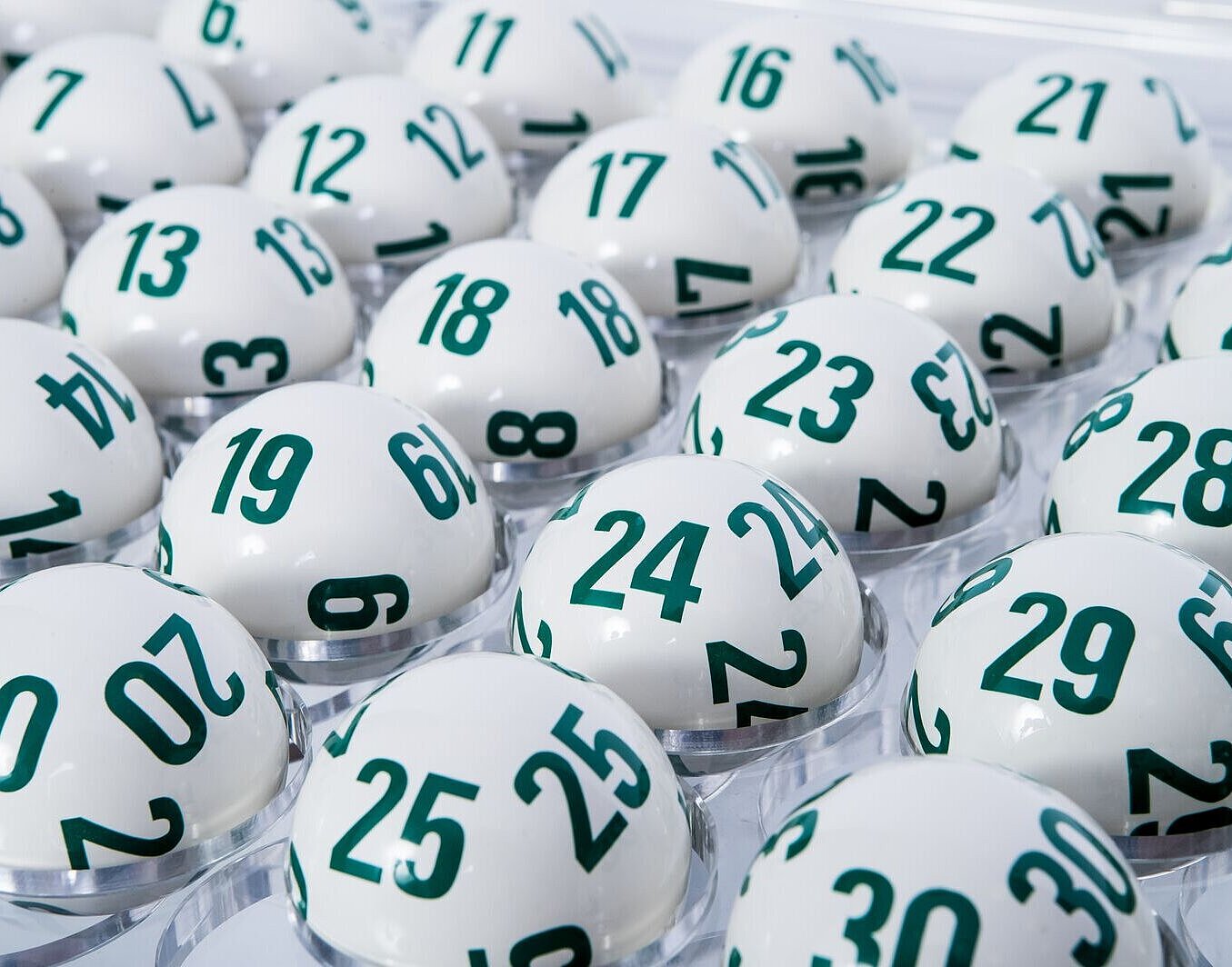 Weiße Lotto-Kugeln für Lotto 6 aus 45 mit den aufgedruckten grünen Lottozahlen