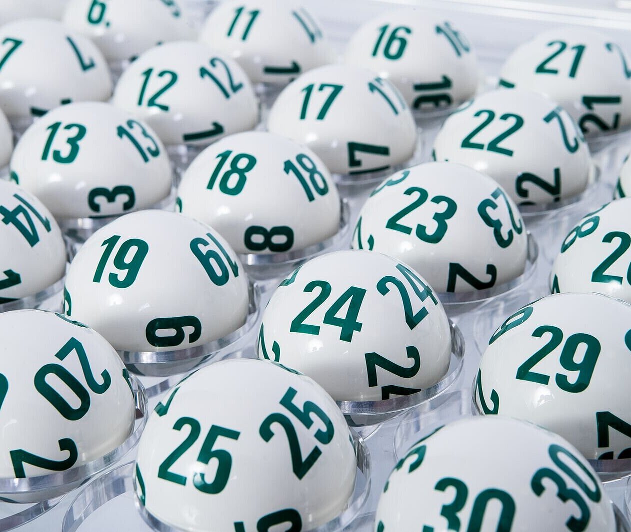 Weiße Lotto-Kugeln für Lotto 6 aus 45 mit den aufgedruckten grünen Lottozahlen