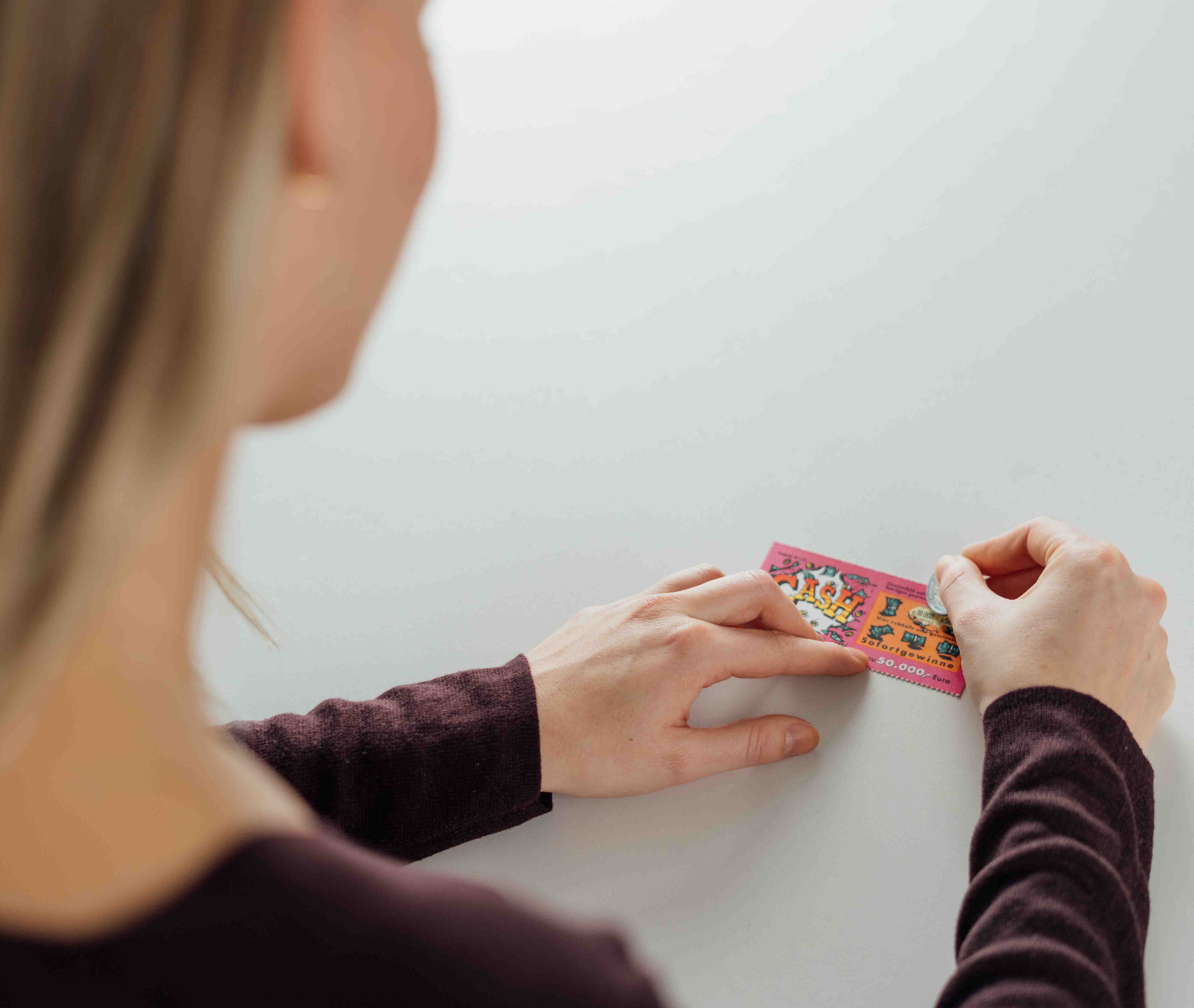 junge Frau rubbelt das Rubbellos Cash auf junge Frau rubbelt das Rubbellos Cash auf