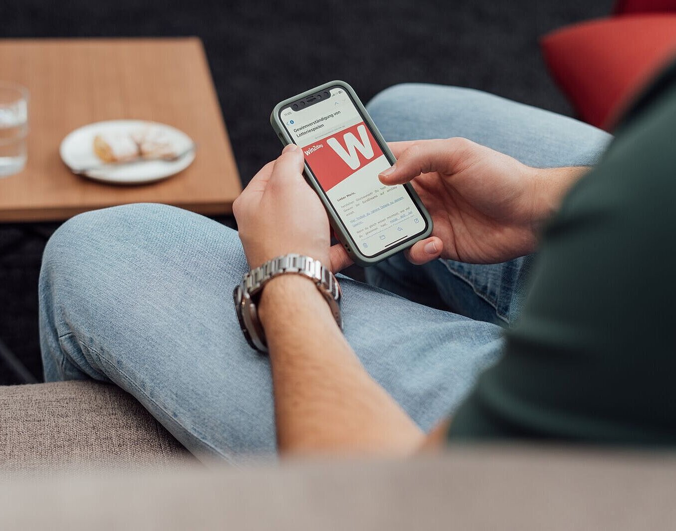 Jemand lässt sich übers Handy den TopTipp-Gewinn der Österreichischen Lotterien auszahlen