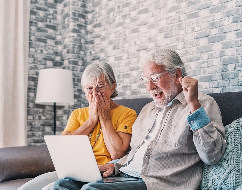 Ein älteres Paar freut sich über einen Lotto-Gewinn
