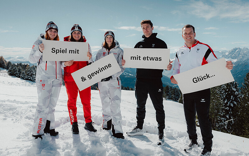 Fünf österreichische Olympia-Stars halten Schilder mit der Aufschrift: Spiel mit und gewinne mit etwas Glück.. eine Reise zu den Olympischen Winterspielen Mailand Cortina 2026. 