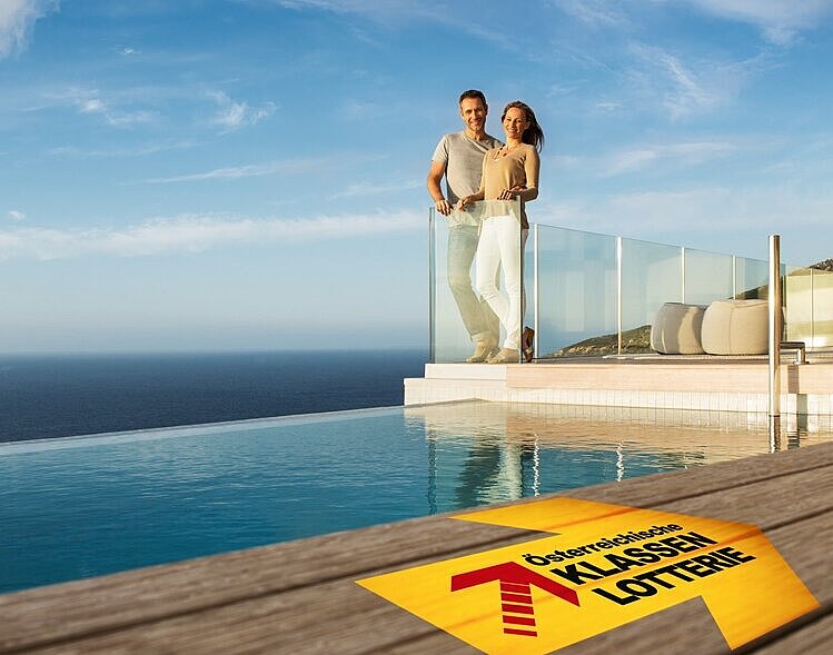 Ein Pärchen auf der Terrasse einer angedeuteten Villa mit Blick aufs Meer, Schriftzug mit Logo der Klassenlotterie